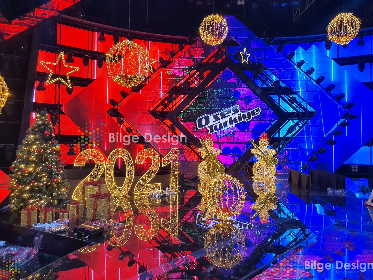 https://bilgedesign.com/images/referans/1889416836-o-ses-turkiye-sahnesi-2021-yilbais-isik-suslemeleri-isikli-toplar-isikli-yildizlar-yilbasi-agaci-calgici-kardan-adam.jpg